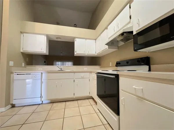 a kitchen with white cabinets appliances and a sink