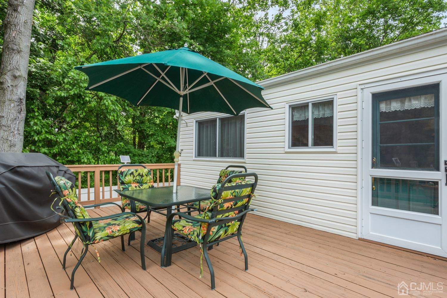 136 Lee Drive Middlesex, NJ 08846 - Photo 28 of 35 a patio with wooden floor a yard a table and chairs