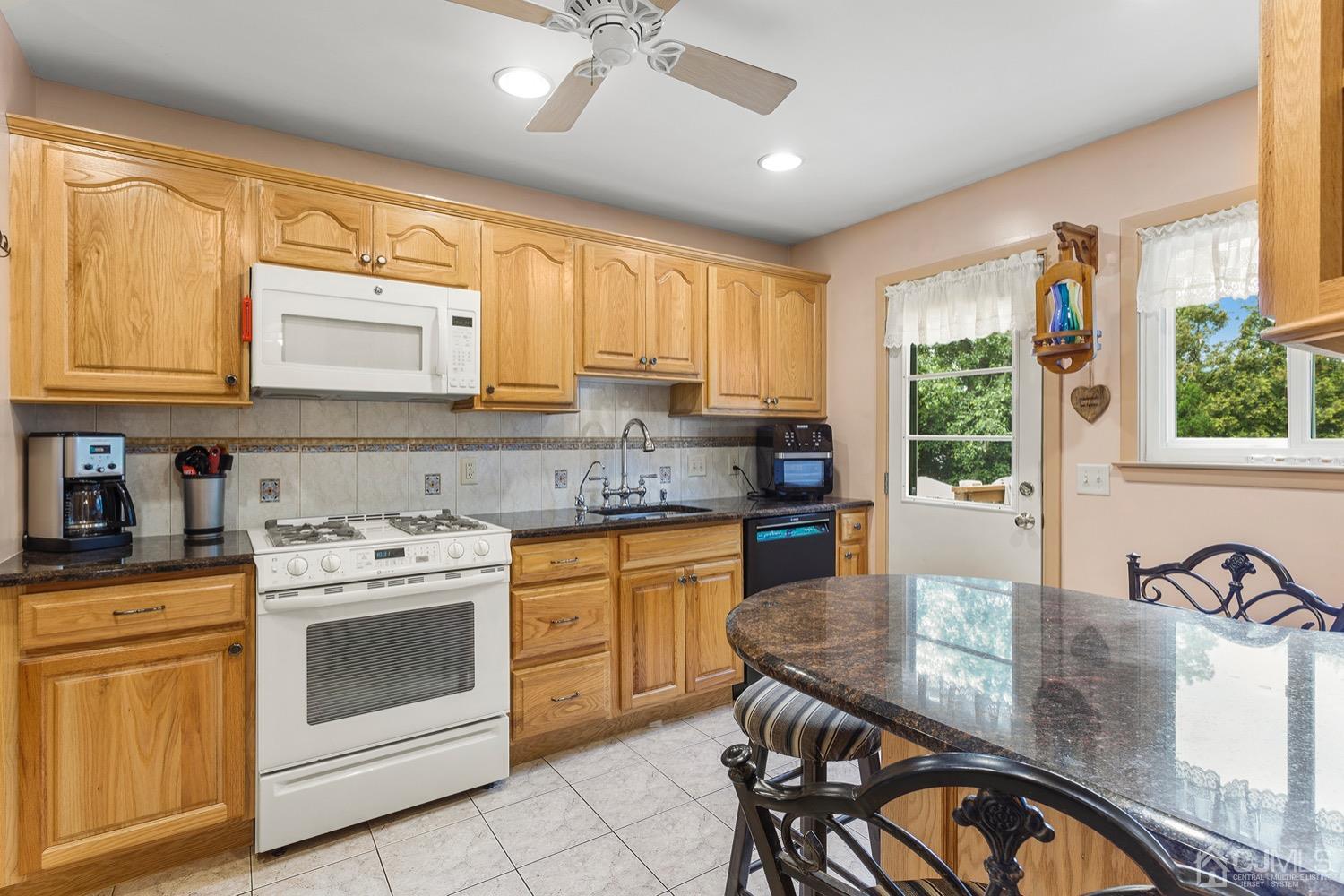 136 Lee Drive Middlesex, NJ 08846 - Photo 7 of 35 a kitchen with stainless steel appliances granite countertop a stove a sink and a microwave