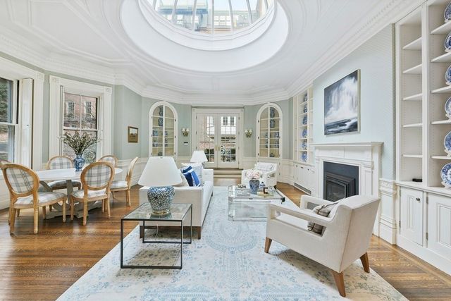 a spacious bedroom with a bed a couch and a chandelier
