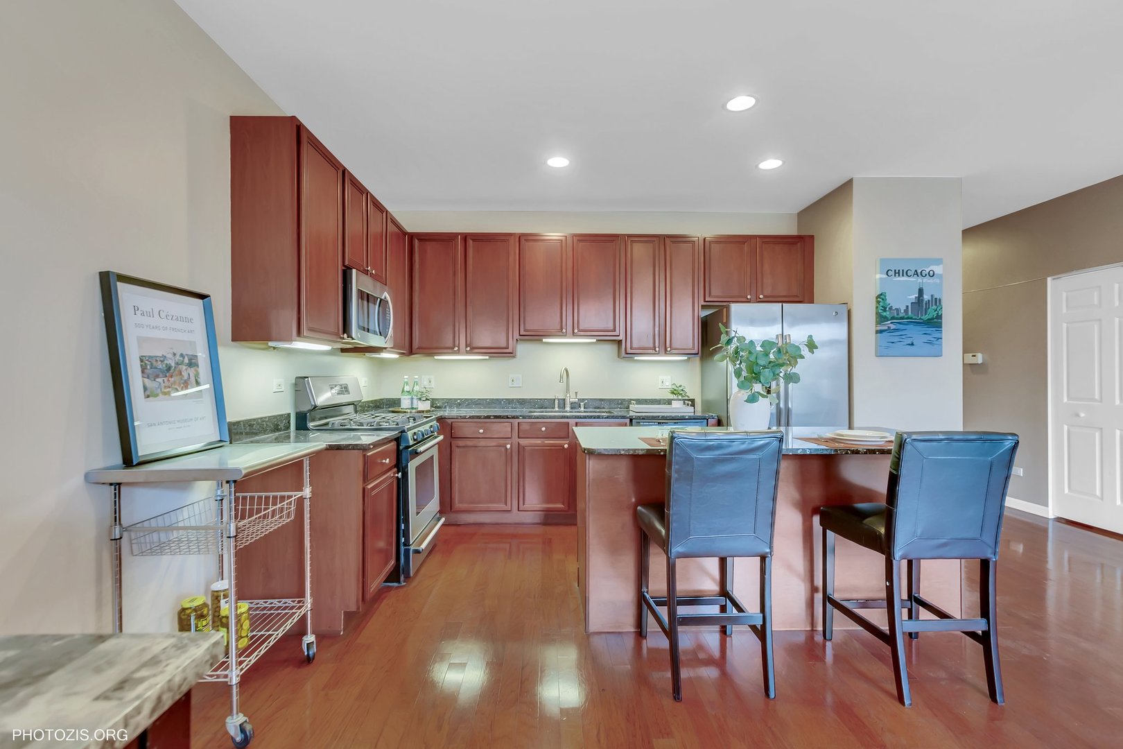 1414 South Halsted Street, Unit 3B Chicago, IL 60607 - Photo 6 of 14 a kitchen with granite countertop a table chairs stove and wooden cabinets