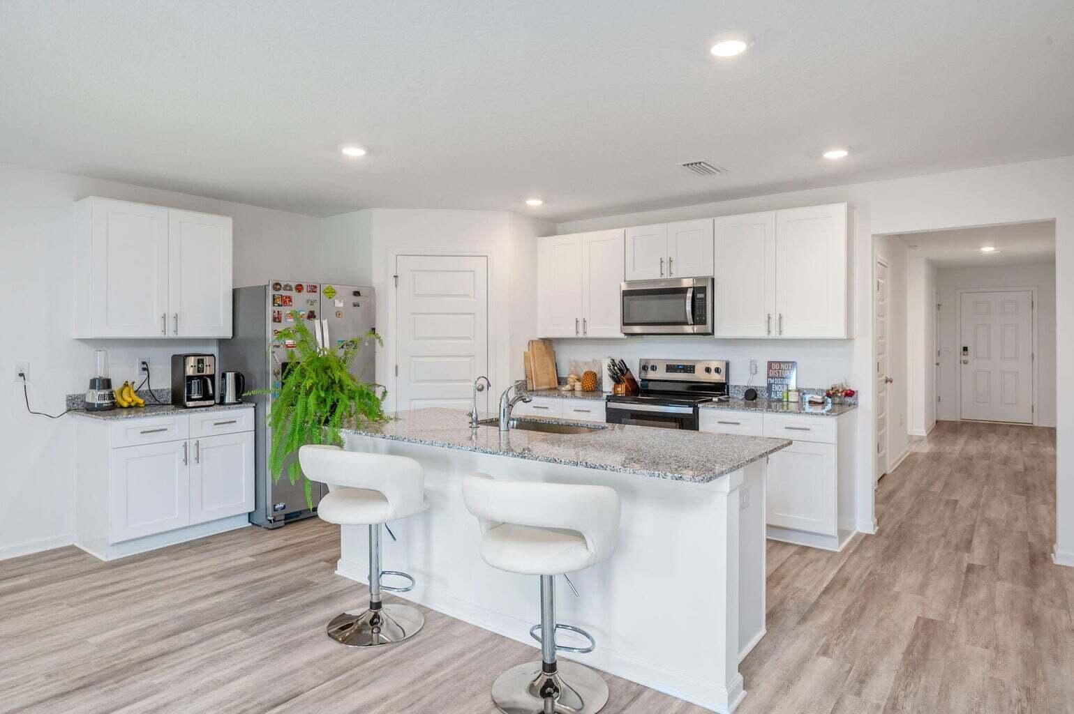 103 Riverwalk Circle Freeport, FL 32439 - Photo 18 of 34 a kitchen with stainless steel appliances granite countertop a stove a sink a refrigerator and a microwave