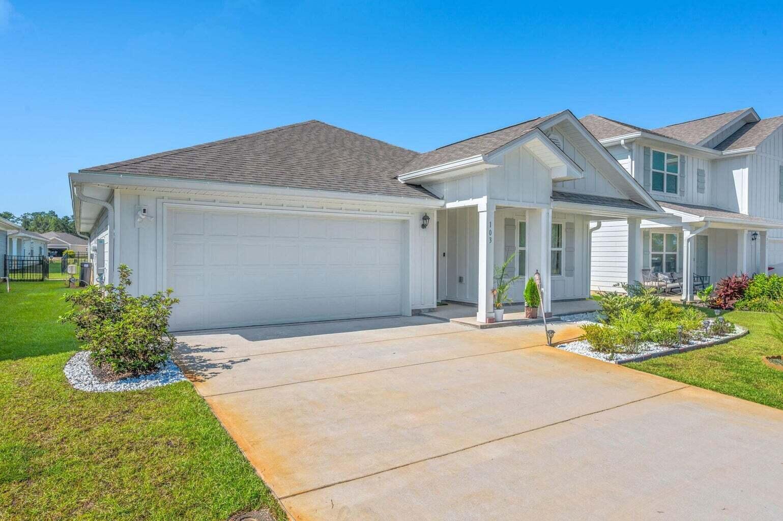 103 Riverwalk Circle Freeport, FL 32439 - Photo 3 of 34 a front view of a house with a yard and potted plants