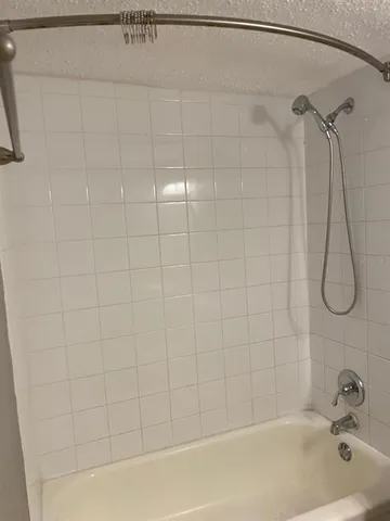 a bathroom with a bath tub with a shower