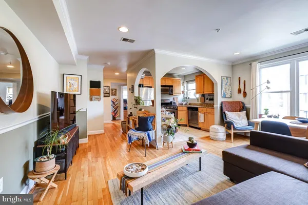 a living room with furniture a large window and wooden floor