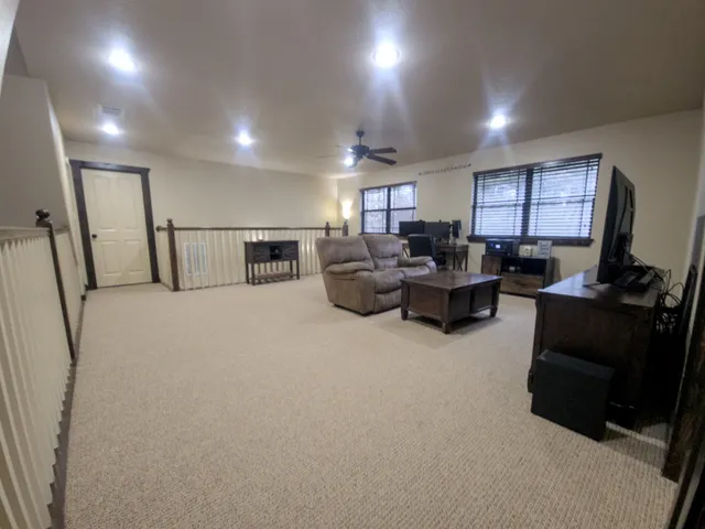 a living room with furniture a flat screen tv and a large window
