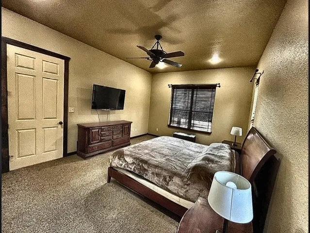 a bedroom with a bed flat screen tv and a fireplace