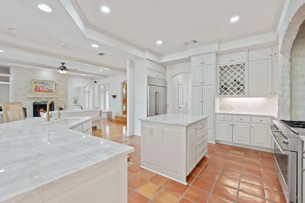 a large white kitchen with a stove a sink a refrigerator and a refrigerator