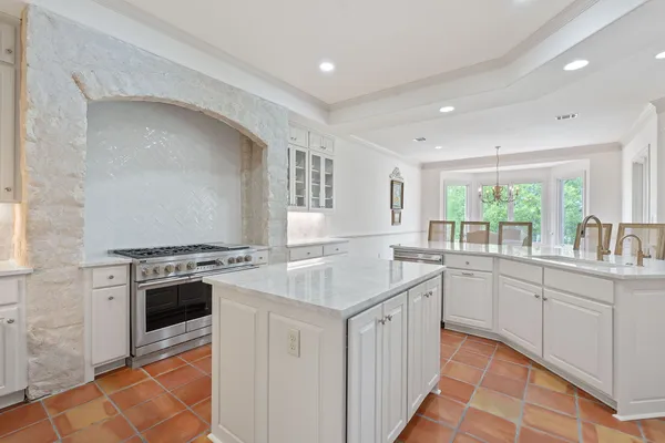 a kitchen with granite countertop a sink stove and refrigerator