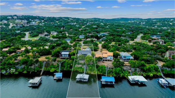 an aerial view of a houses with a yard and lake view