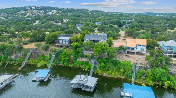 an aerial view of a house with a yard and lake view