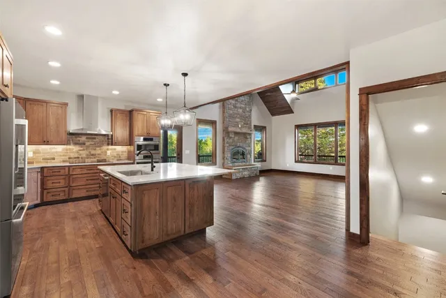 a kitchen with stainless steel appliances granite countertop a stove and a wooden floors