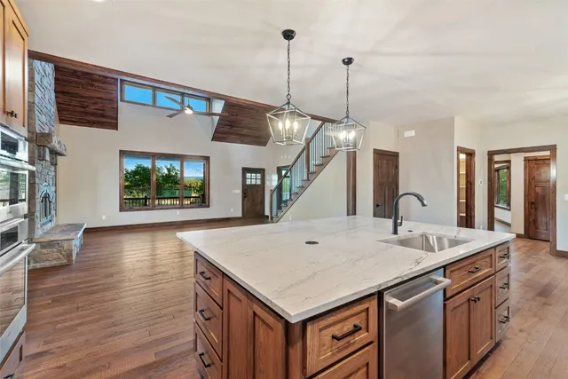 a view of a kitchen island a sink and wooden floor