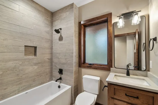 a bathroom with a granite countertop sink mirror toilet and bathtub