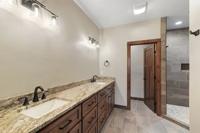 a spacious bathroom with a granite countertop sink and a mirror