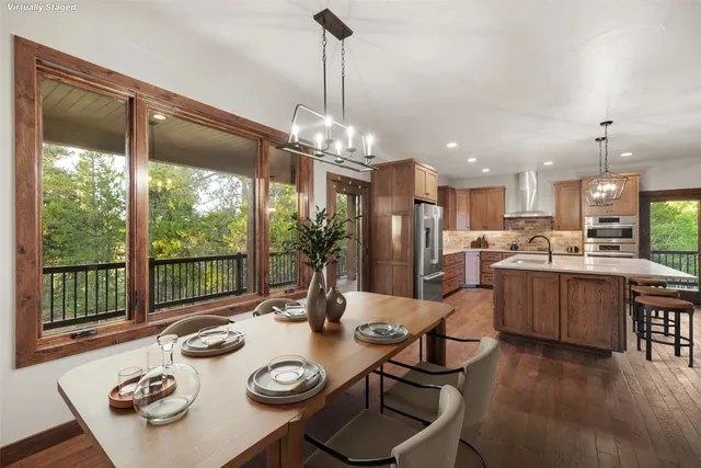 a open dining room with stainless steel appliances furniture large window and dining table