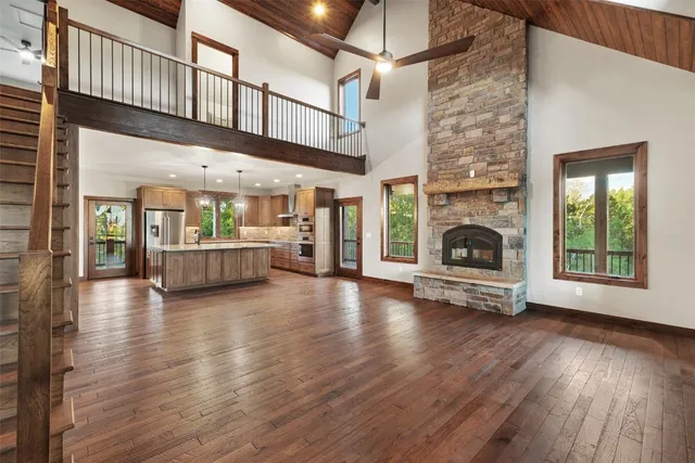 a view of an empty room with wooden floor fireplace and a window