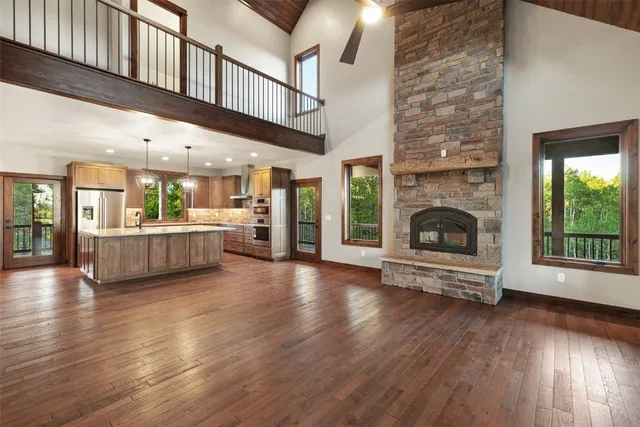 a view of a big room with wooden floor a fireplace and windows