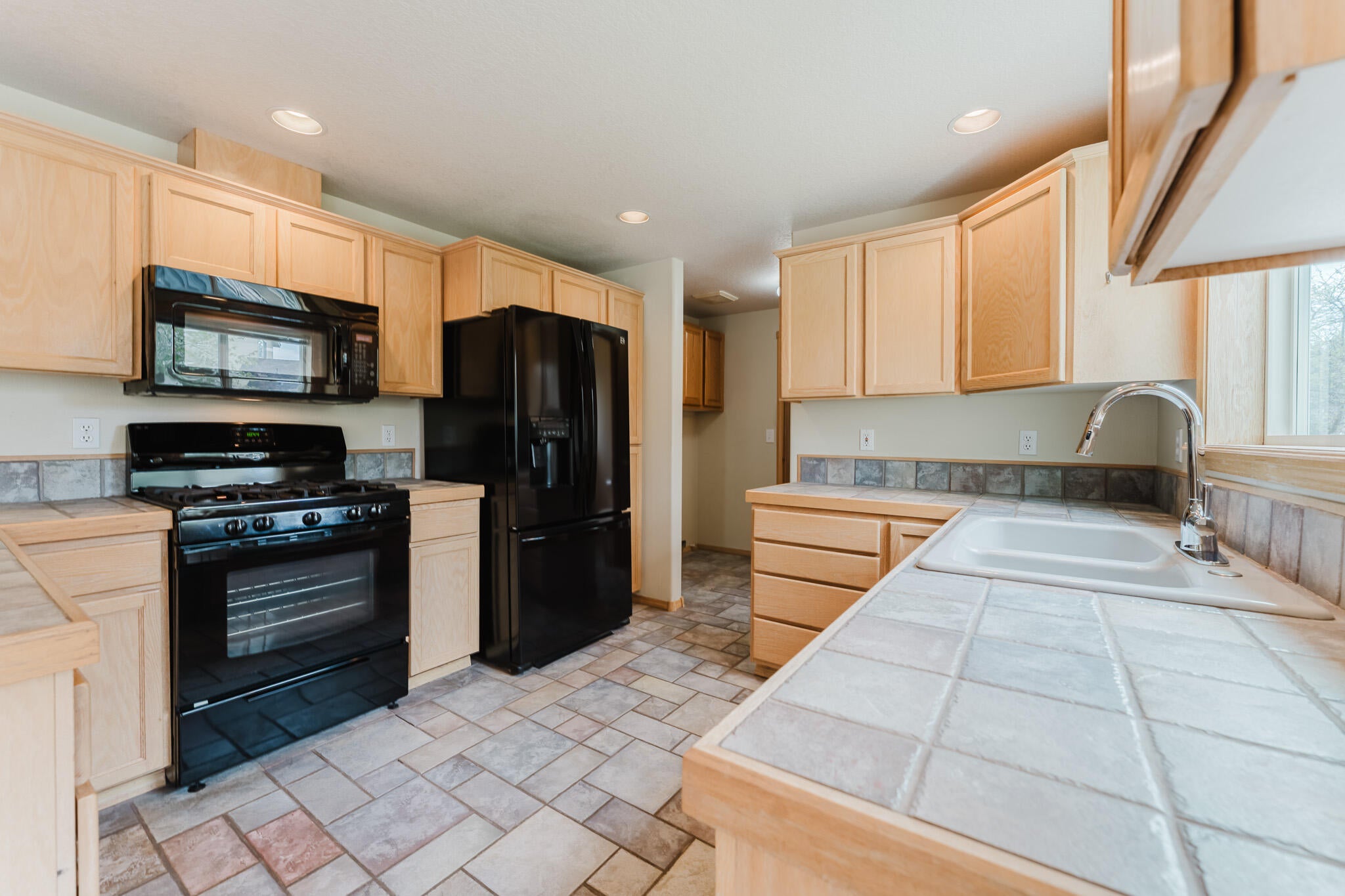3626 Southwest Volcano Court Redmond, OR 97756 - Photo 15 of 89 The kitchen has tiled floors and counters. It also includes the refrigerator.