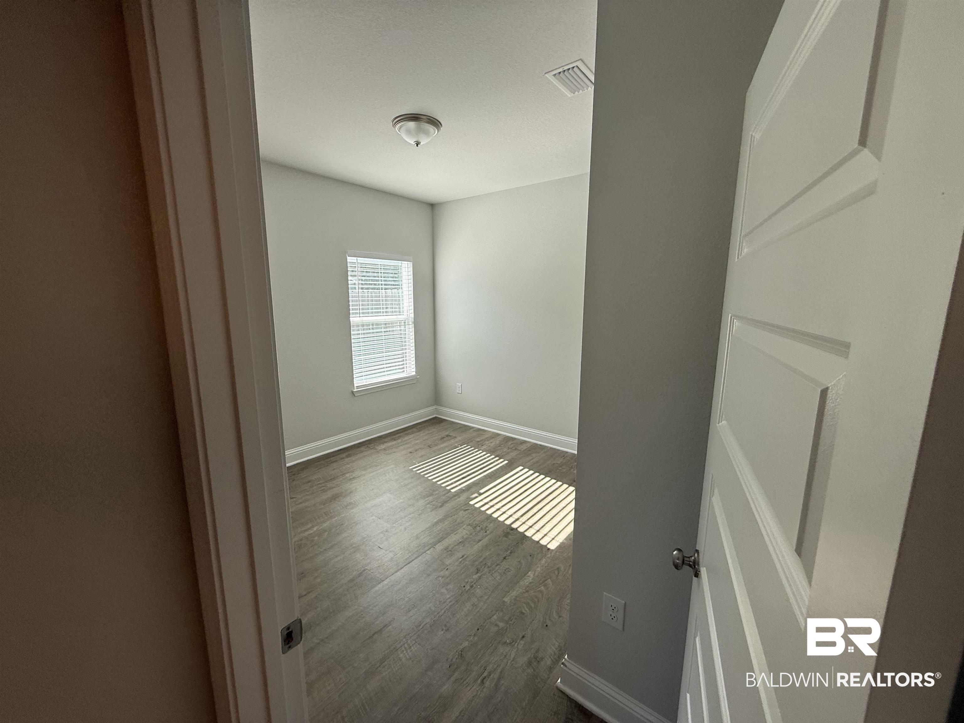 23247 Lieutenant Avenue Foley, AL 36535 - Photo 8 of 47 Bedroom featuring wood-finish flooring, a window with blinds, a ceiling-mounted light fixture, and light gray wall paint