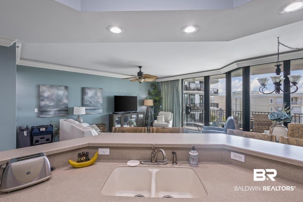 27582 Canal Road, Unit 2408 Orange Beach, AL 36561 - Photo 6 of 47 Kitchen featuring sink, ceiling fan with notable chandelier, and ornamental molding