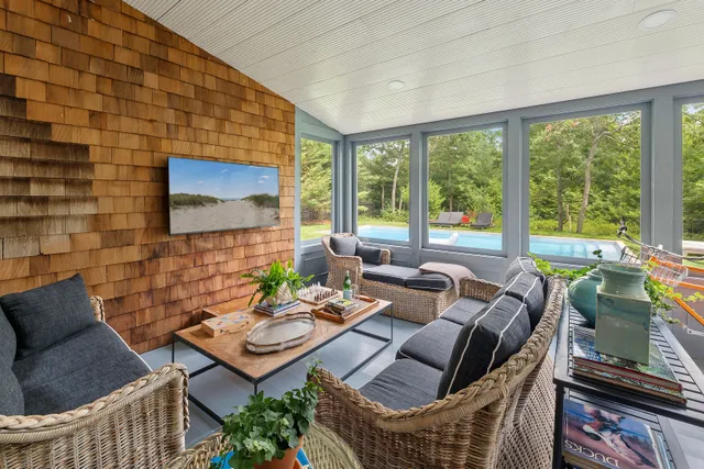 a living room with furniture a flat screen tv and a floor to ceiling window