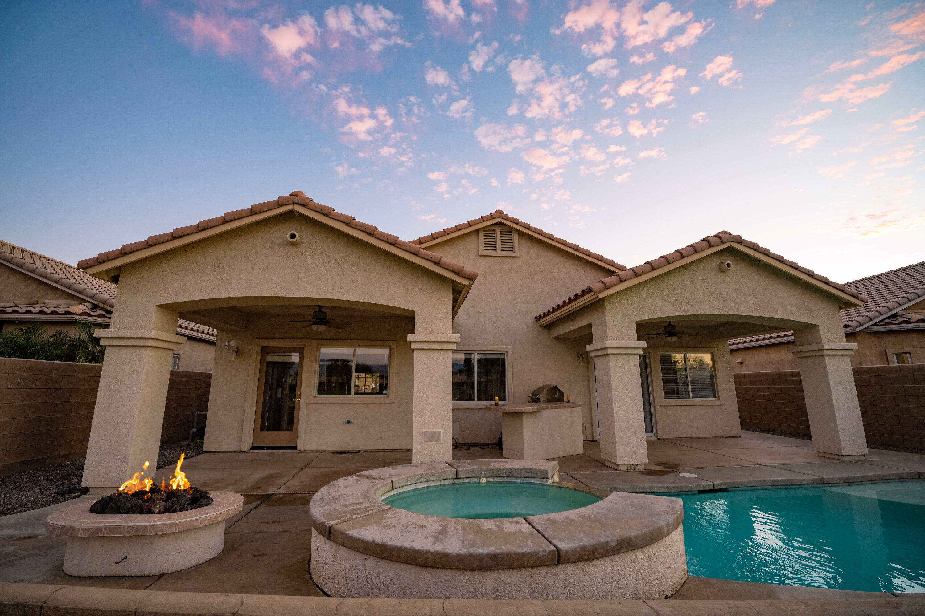 80162 Pebble Beach Drive Indio, CA 92201 - Photo 2 of 48 a front view of a house with a yard fire pit and outdoor seating