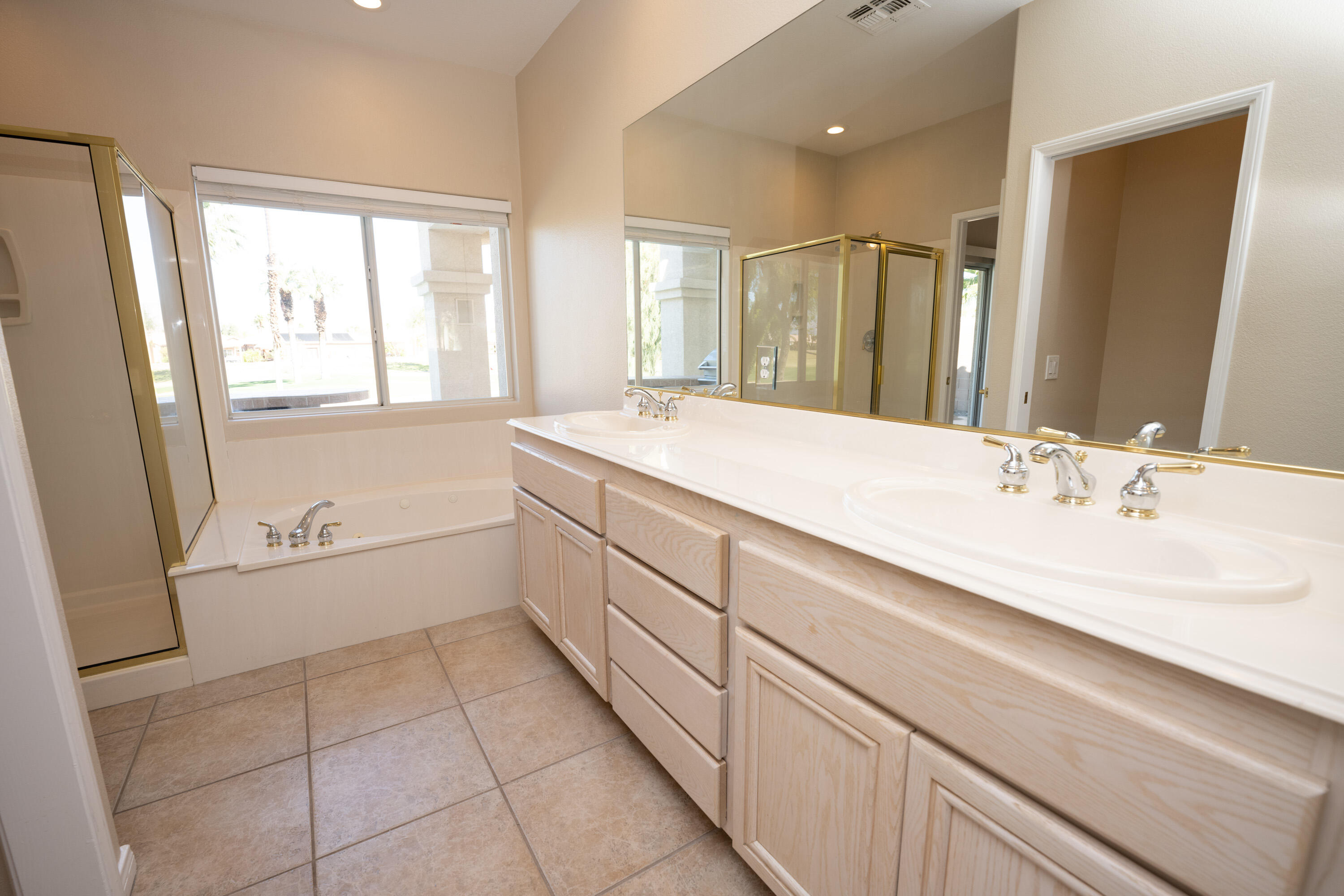 80162 Pebble Beach Drive Indio, CA 92201 - Photo 21 of 48 a spacious bathroom with a granite countertop sink a mirror and a bathtub