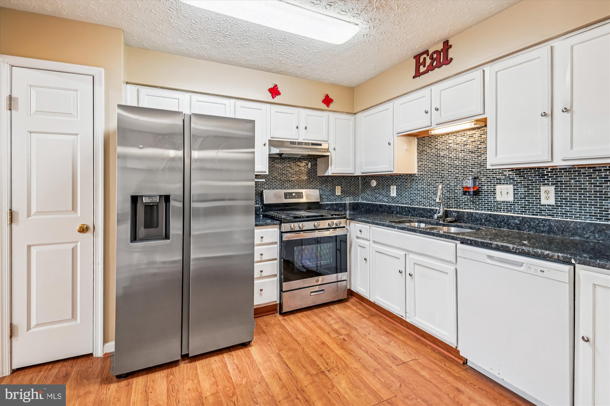 8018 Brookmead Court Severn, MD 21144 - Photo 8 of 35 a kitchen with granite countertop a refrigerator oven a sink and cabinets