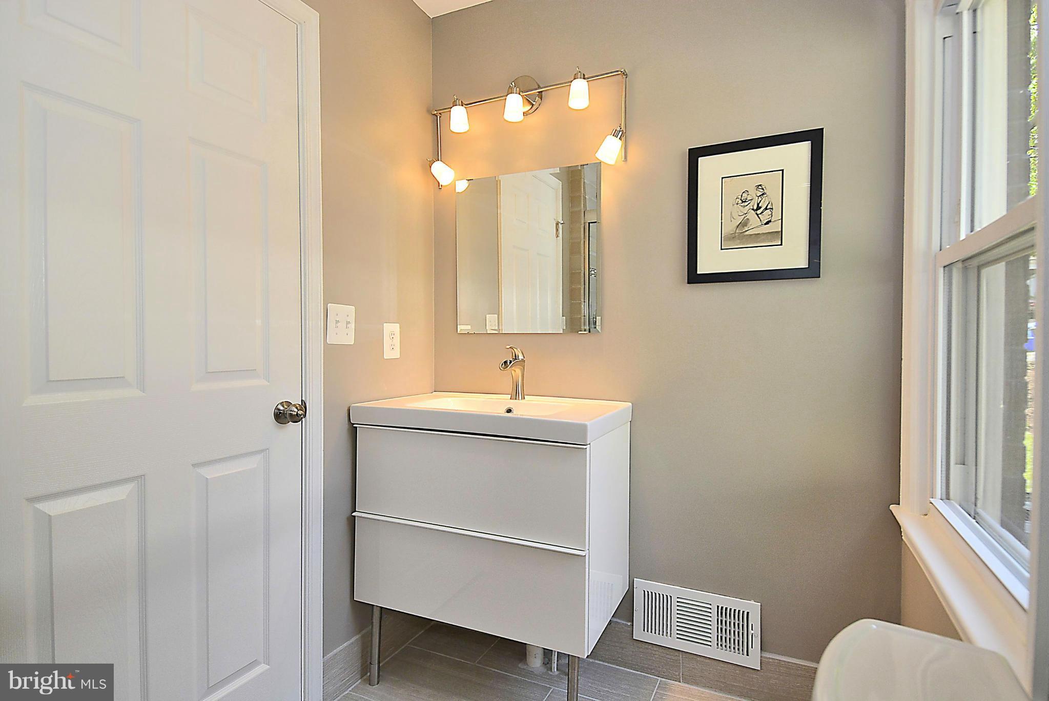 409 Branch Drive Silver Spring, MD 20901 - Photo 13 of 30 a bathroom with a toilet sink and mirror
