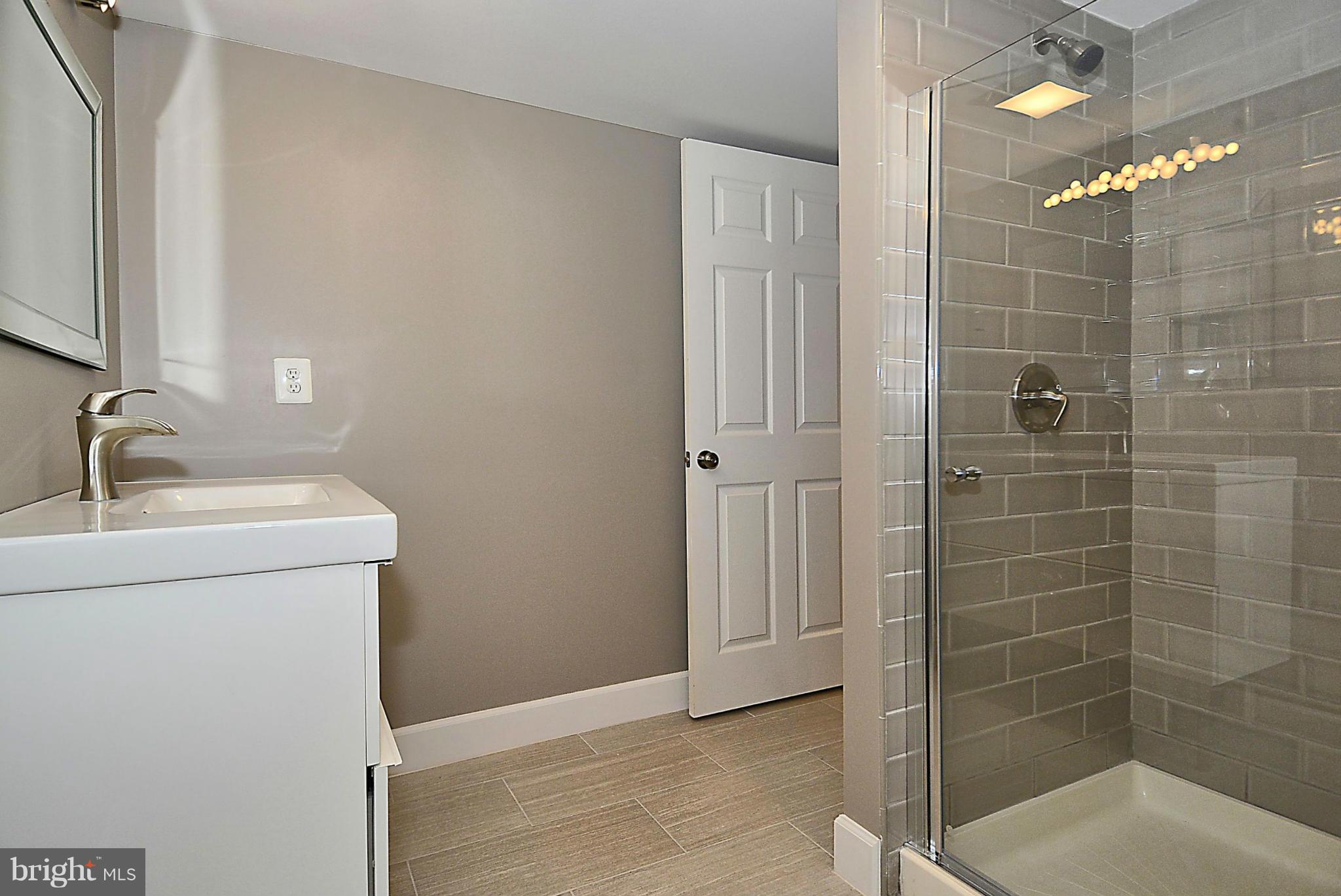 409 Branch Drive Silver Spring, MD 20901 - Photo 23 of 30 a bathroom with a shower a sink and mirror