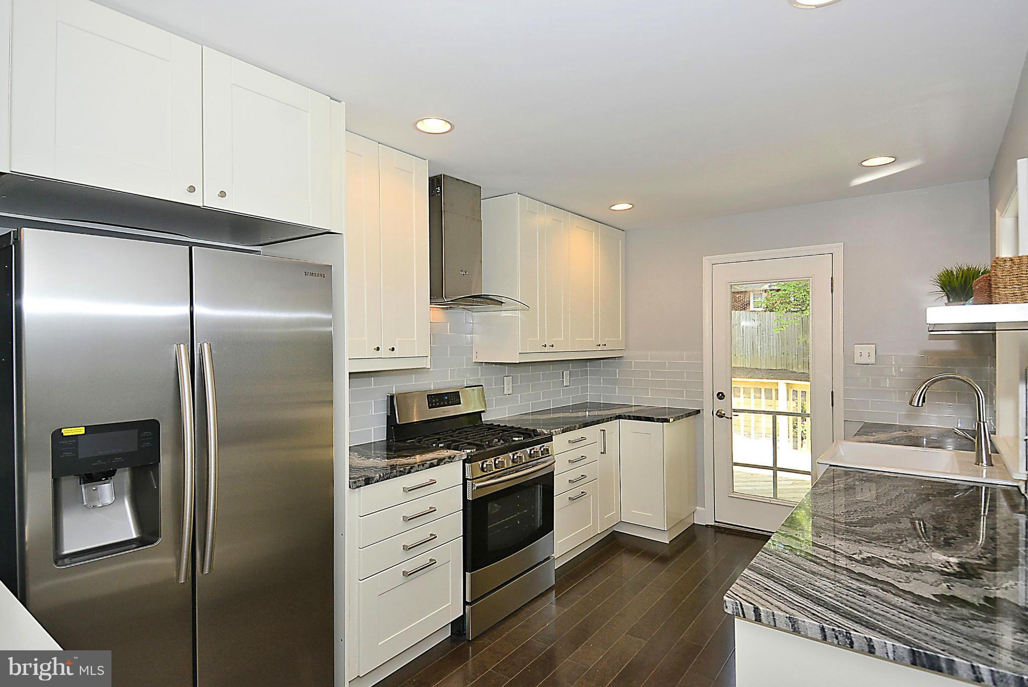 409 Branch Drive Silver Spring, MD 20901 - Photo 7 of 30 a kitchen with stainless steel appliances a refrigerator sink and white cabinets