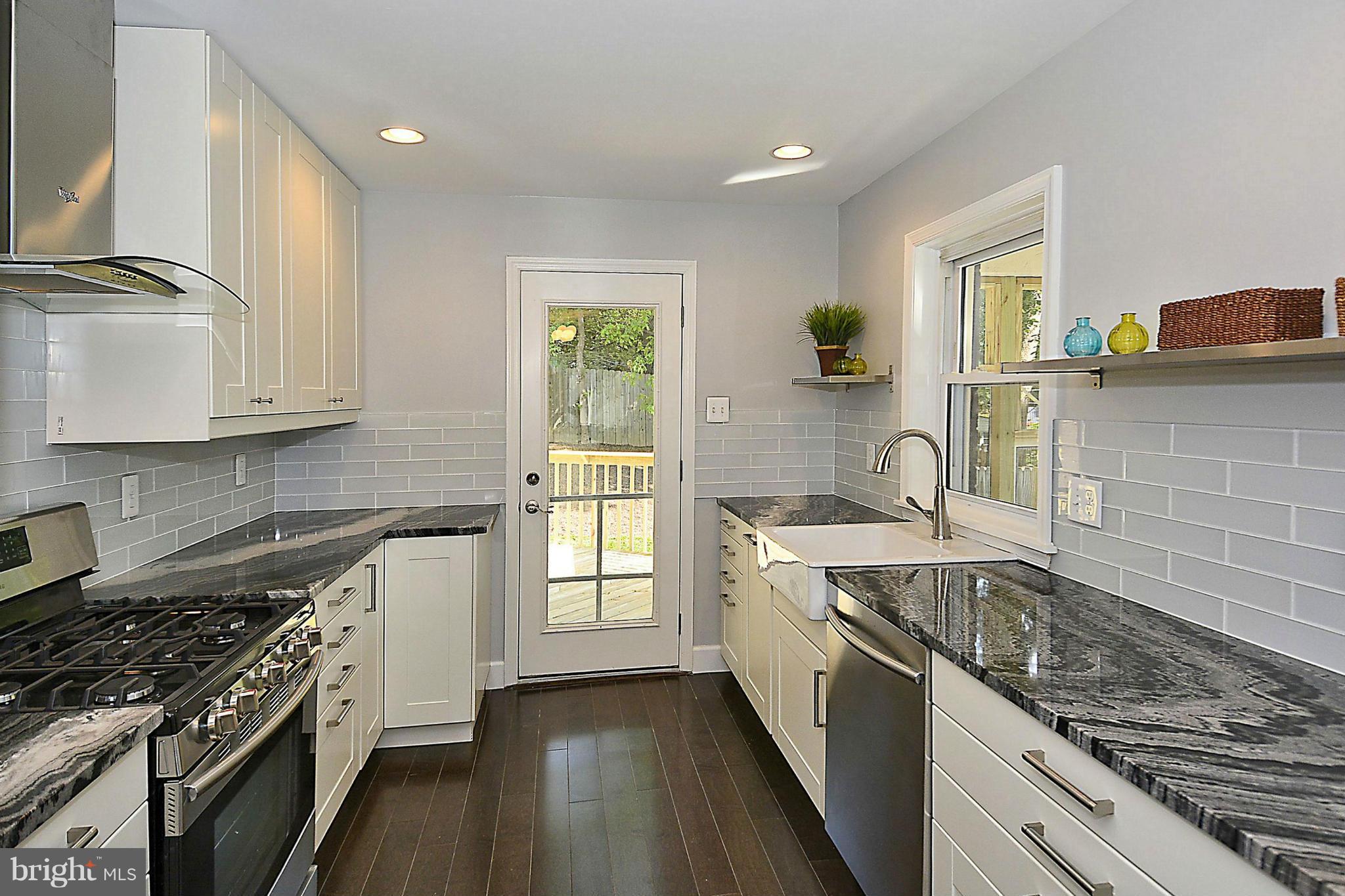 409 Branch Drive Silver Spring, MD 20901 - Photo 9 of 30 a kitchen with granite countertop a sink stove and cabinets