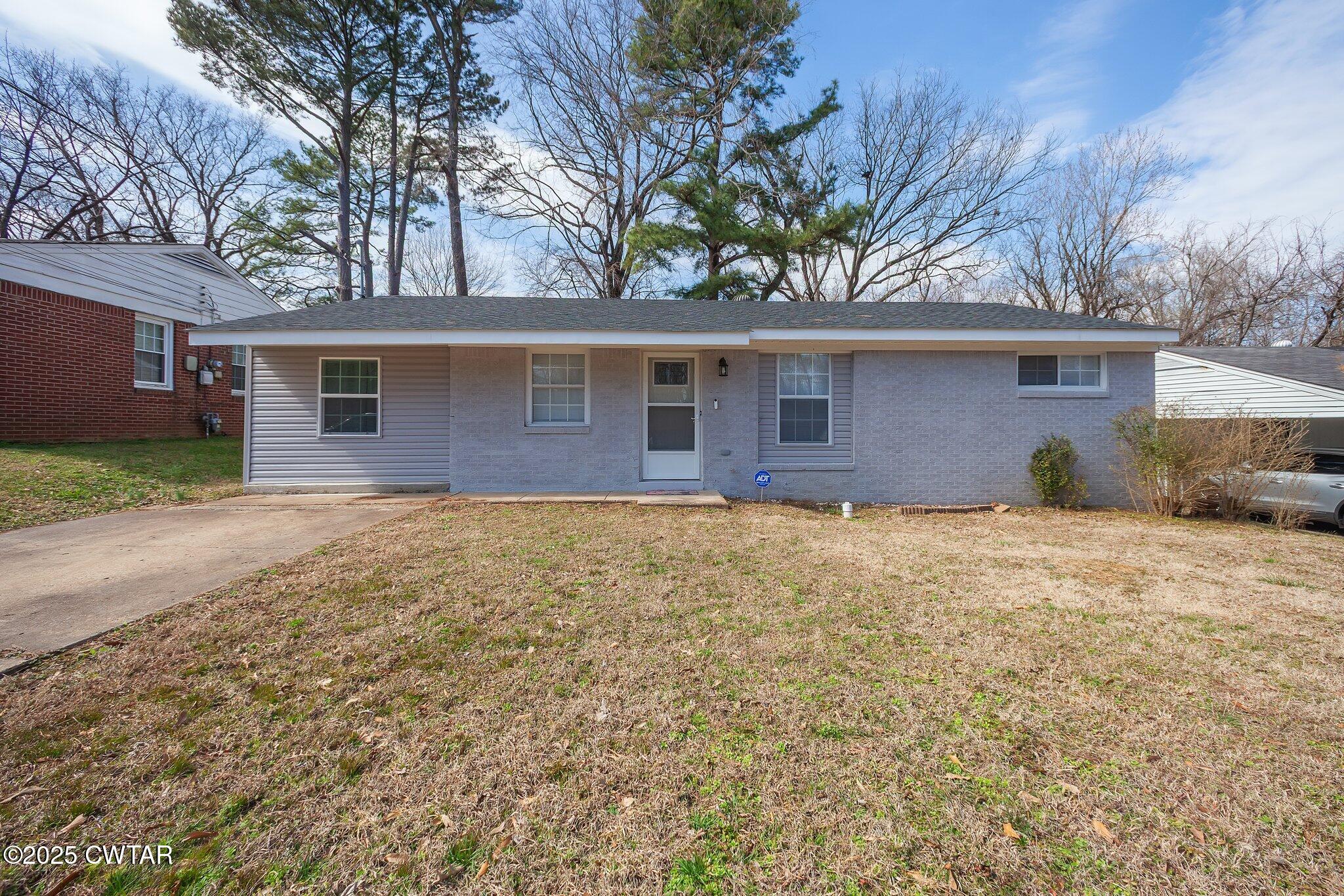 a front view of house with yard and trees