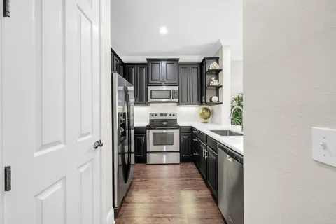 a kitchen with stainless steel appliances granite countertop a refrigerator and a stove