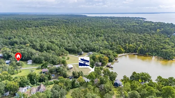 an aerial view of a house with a yard and lake view