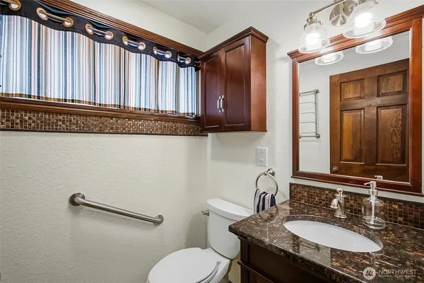a bathroom with a granite countertop sink and a mirror