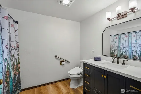a bathroom with a double vanity sink toilet and a mirror