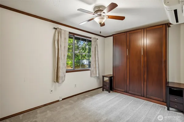an empty room with windows and fan