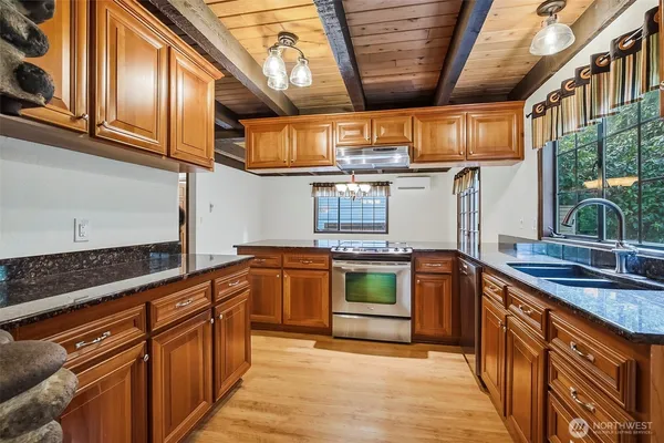 a kitchen with stainless steel appliances granite countertop a sink and stove