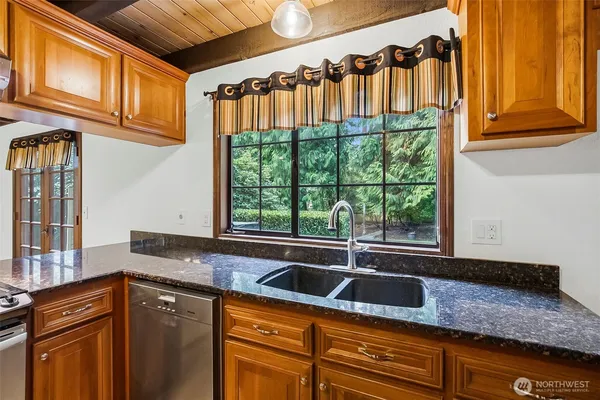 a kitchen with granite countertop a sink and a window