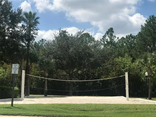 a view of a house with a yard and large trees