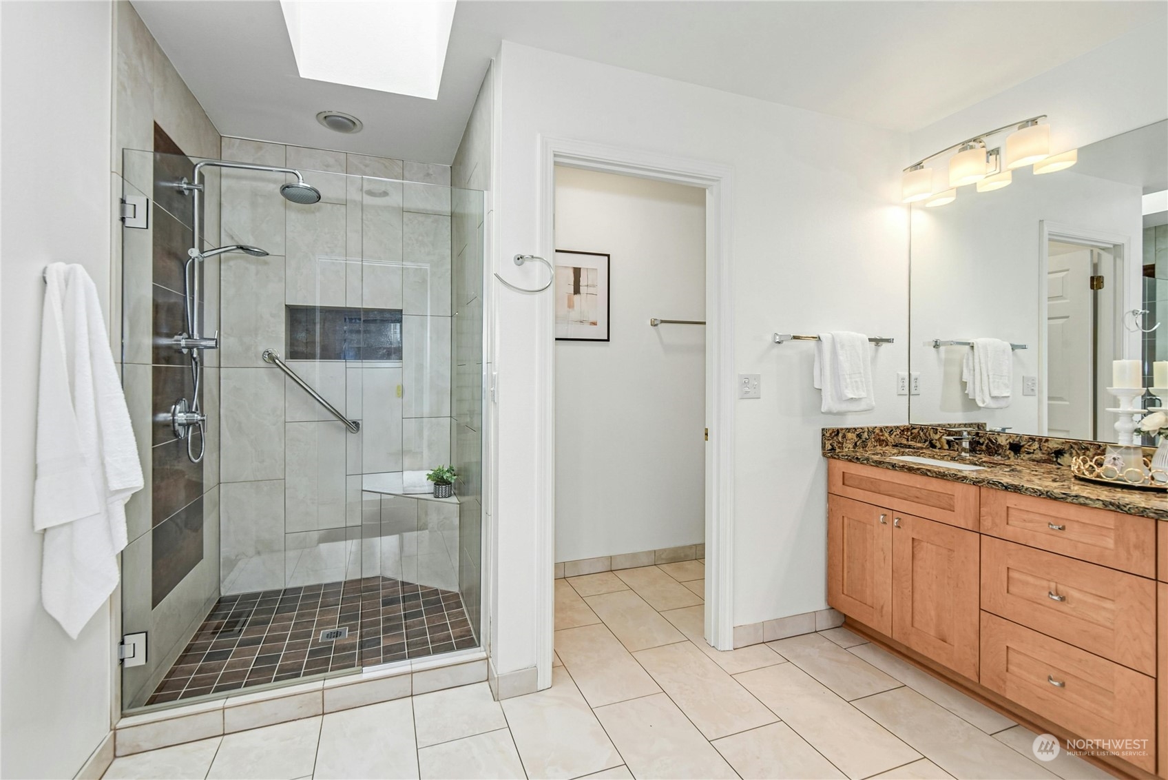 1310 North 41st Street, Unit B Seattle, WA 98103 - Photo 24 of 40 a bathroom with a granite countertop sink a mirror a vanity and a shower