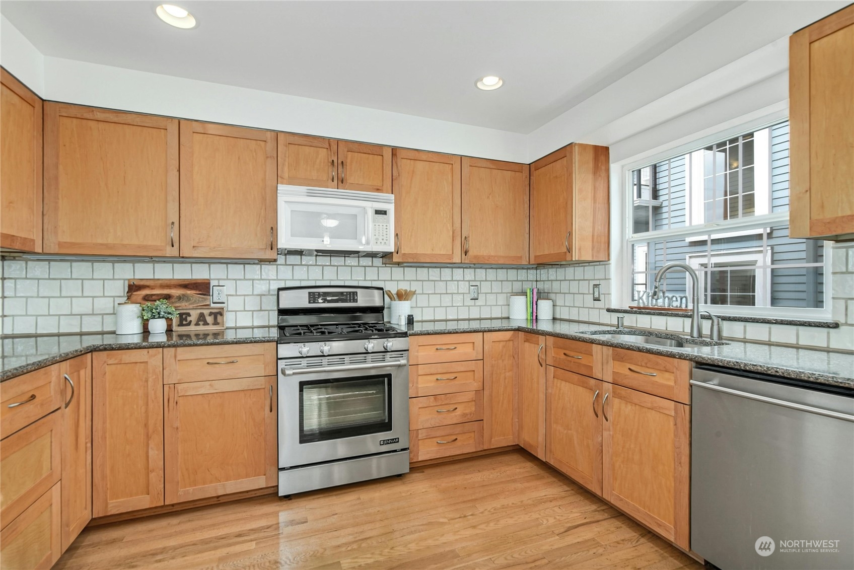 1310 North 41st Street, Unit B Seattle, WA 98103 - Photo 9 of 40 a kitchen with stainless steel appliances granite countertop a stove a sink and white cabinets