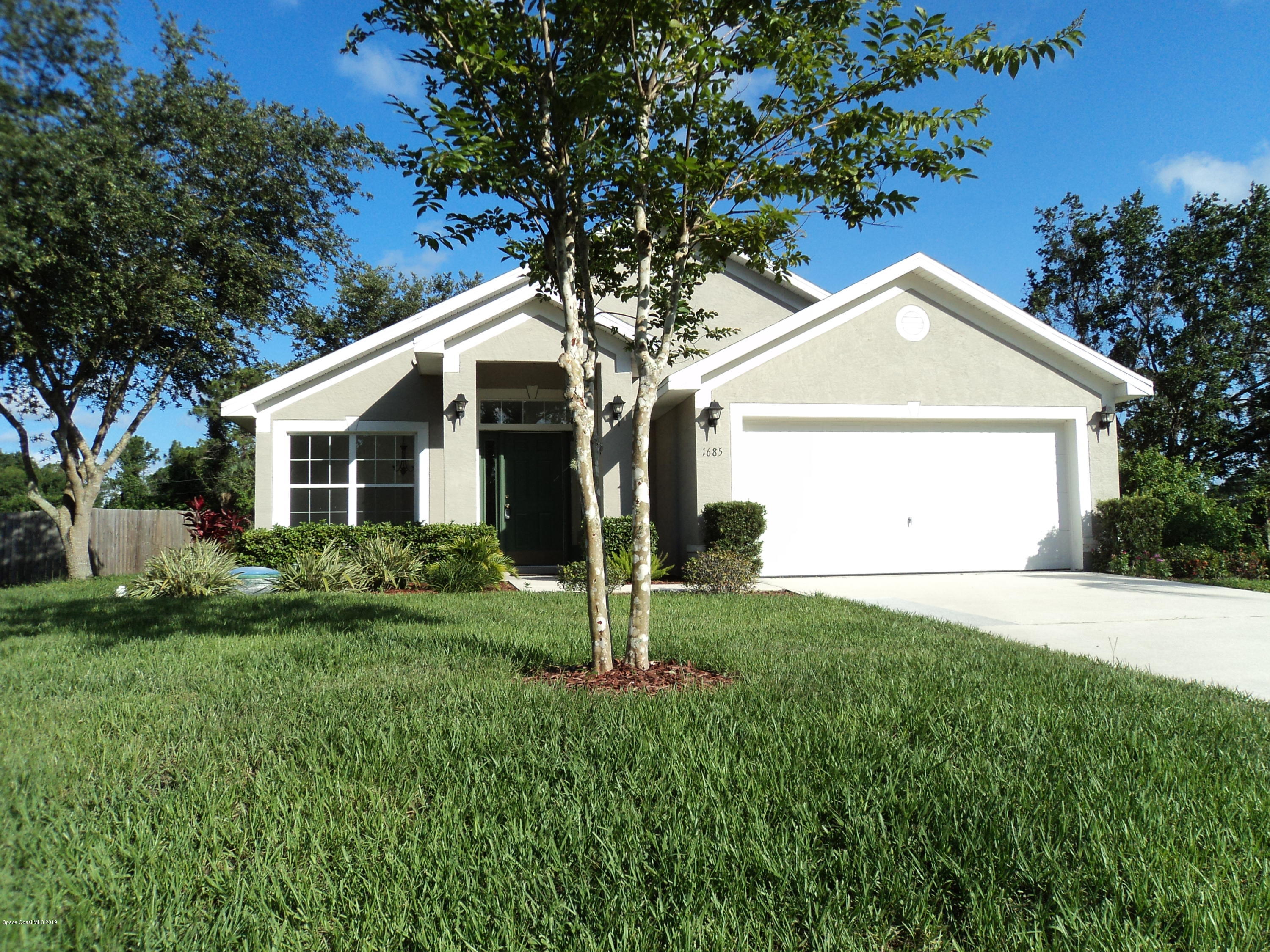 1685 Wacker Avenue Southeast Palm Bay, FL 32909 - Photo 1 of 30 a front view of a house with a yard and garage