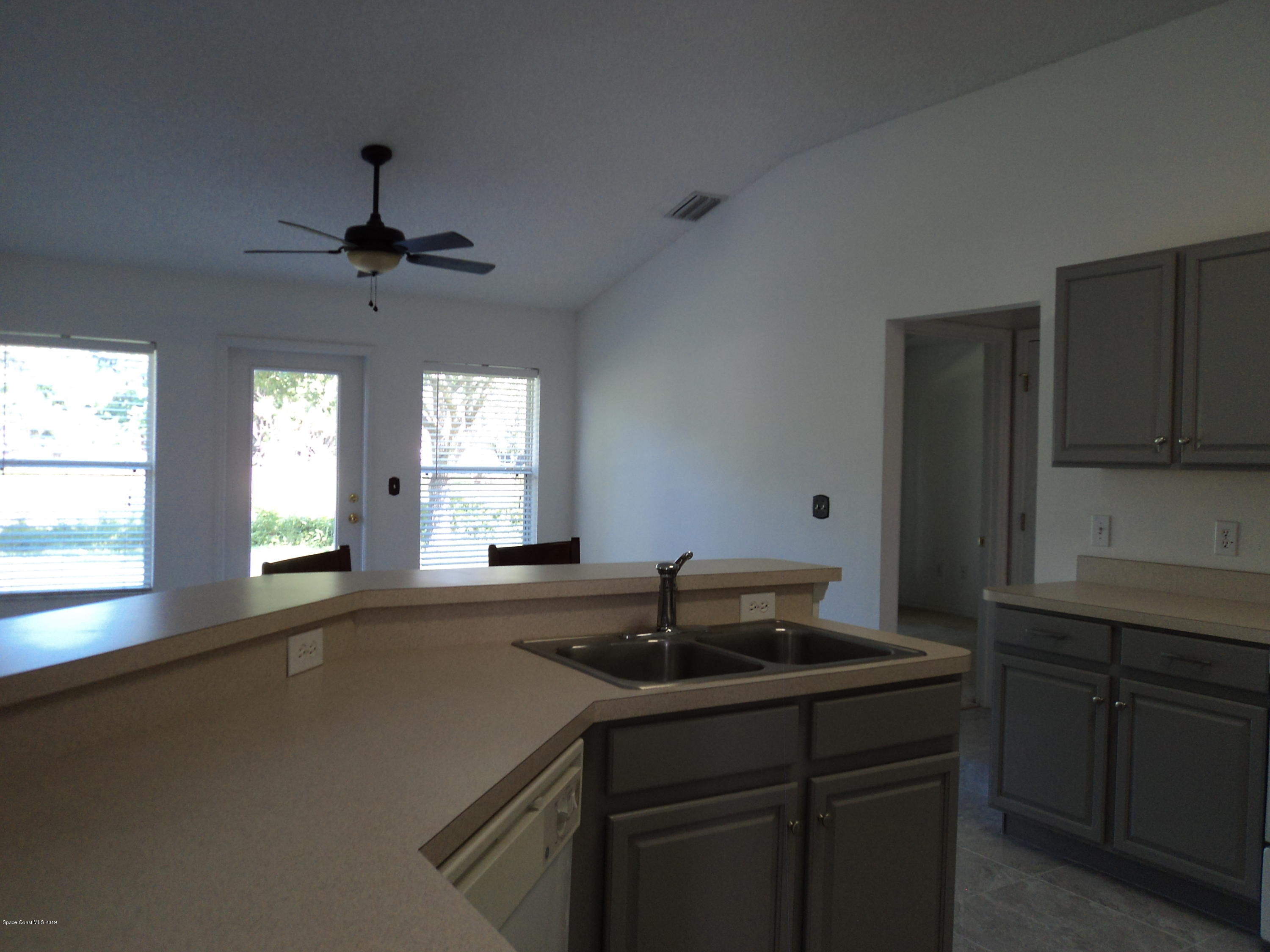 1685 Wacker Avenue Southeast Palm Bay, FL 32909 - Photo 17 of 30 a kitchen with a sink a window and stainless steel appliances