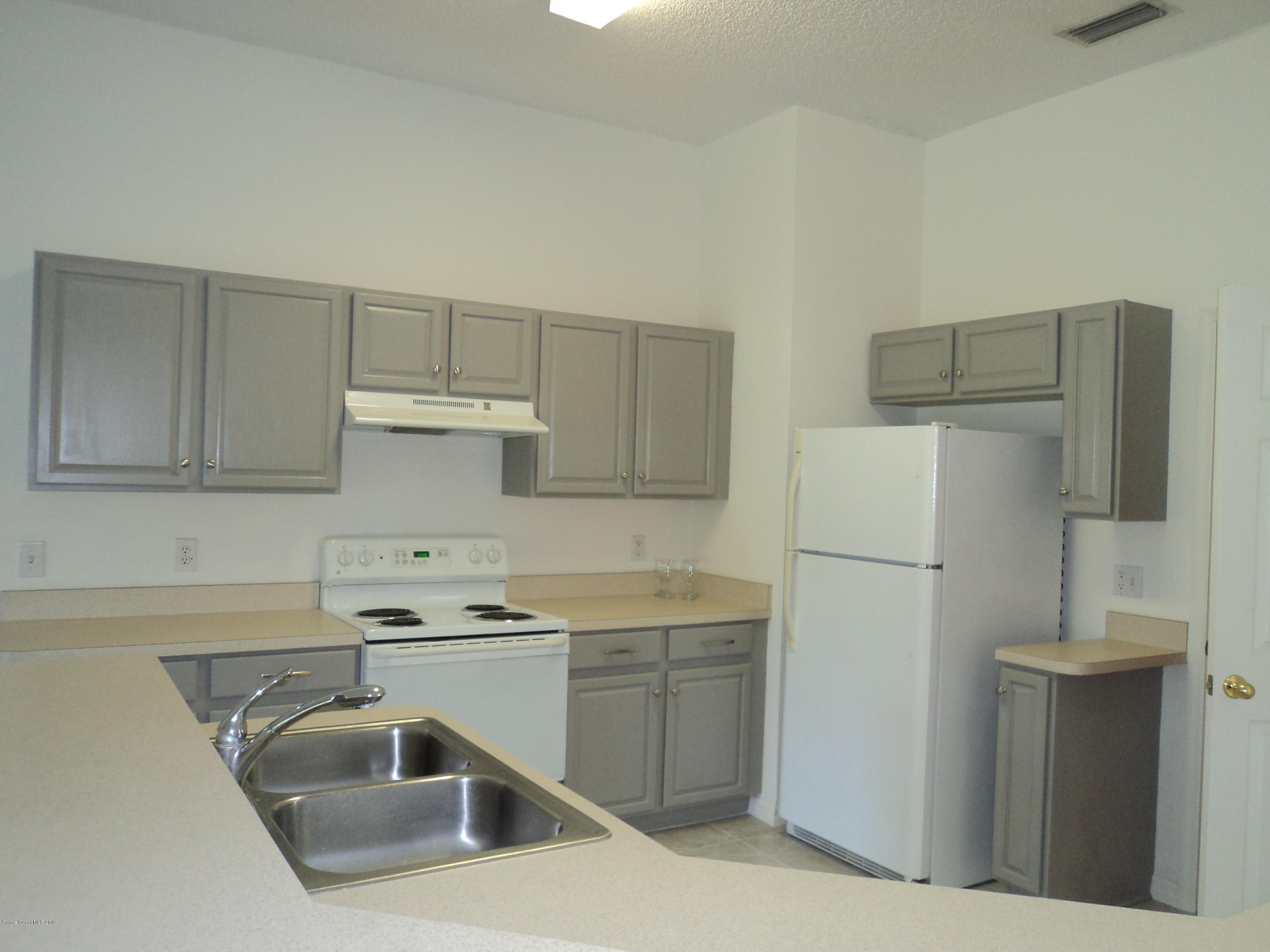 1685 Wacker Avenue Southeast Palm Bay, FL 32909 - Photo 18 of 30 a kitchen with a sink a refrigerator and cabinets