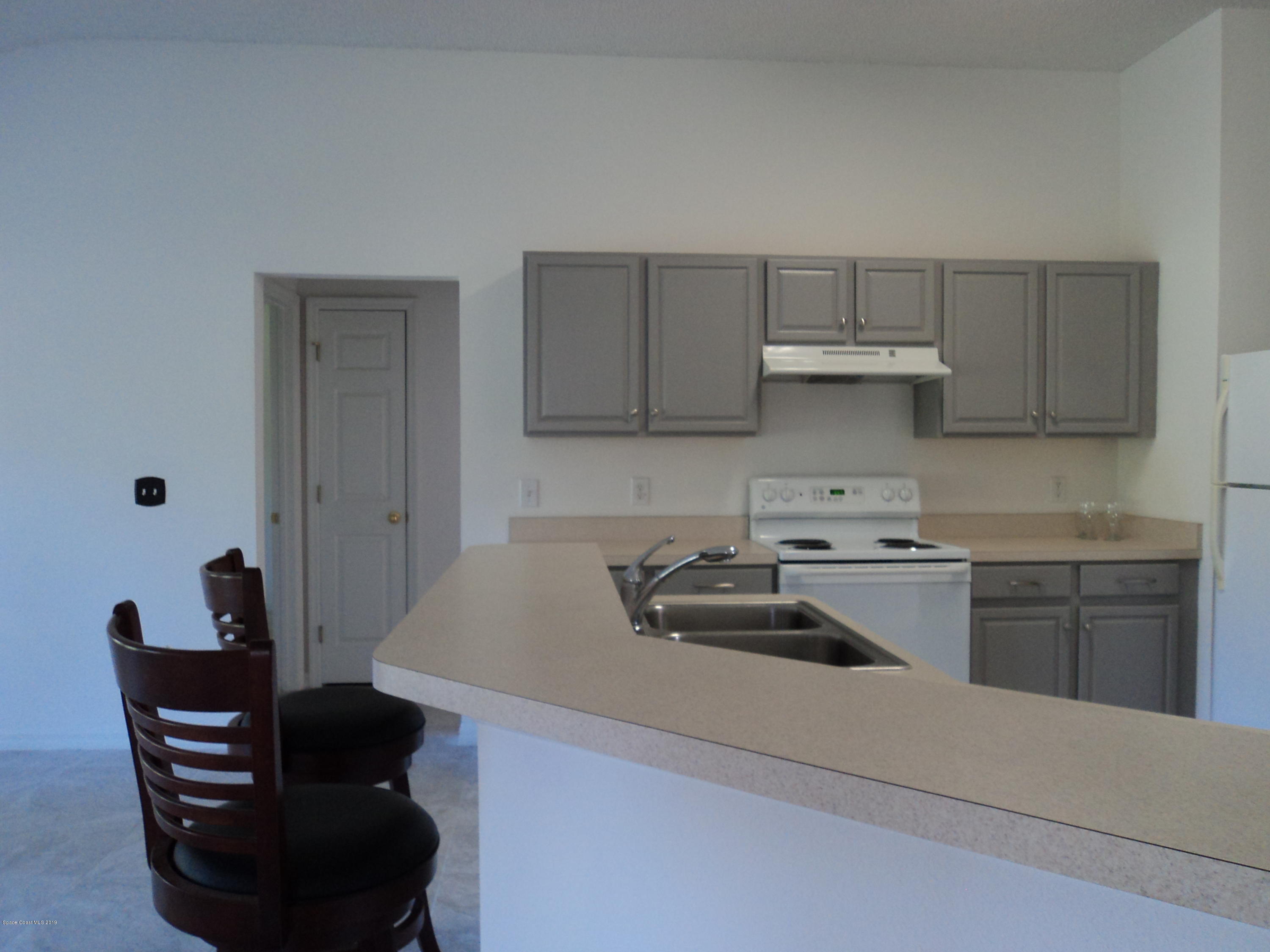 1685 Wacker Avenue Southeast Palm Bay, FL 32909 - Photo 3 of 30 a kitchen with stainless steel appliances a sink a stove a refrigerator and cabinets