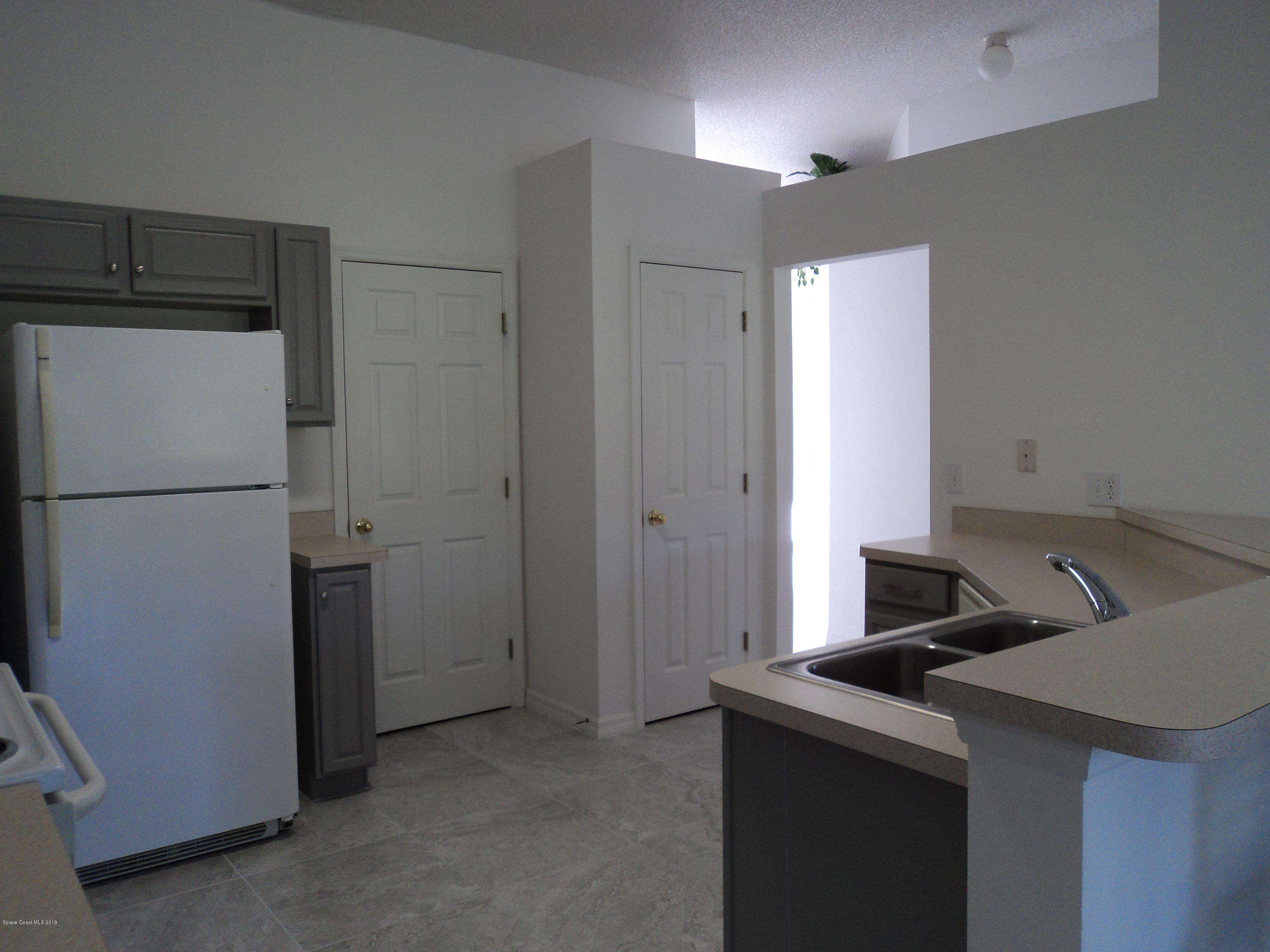 1685 Wacker Avenue Southeast Palm Bay, FL 32909 - Photo 24 of 30 a kitchen with a refrigerator and cabinets