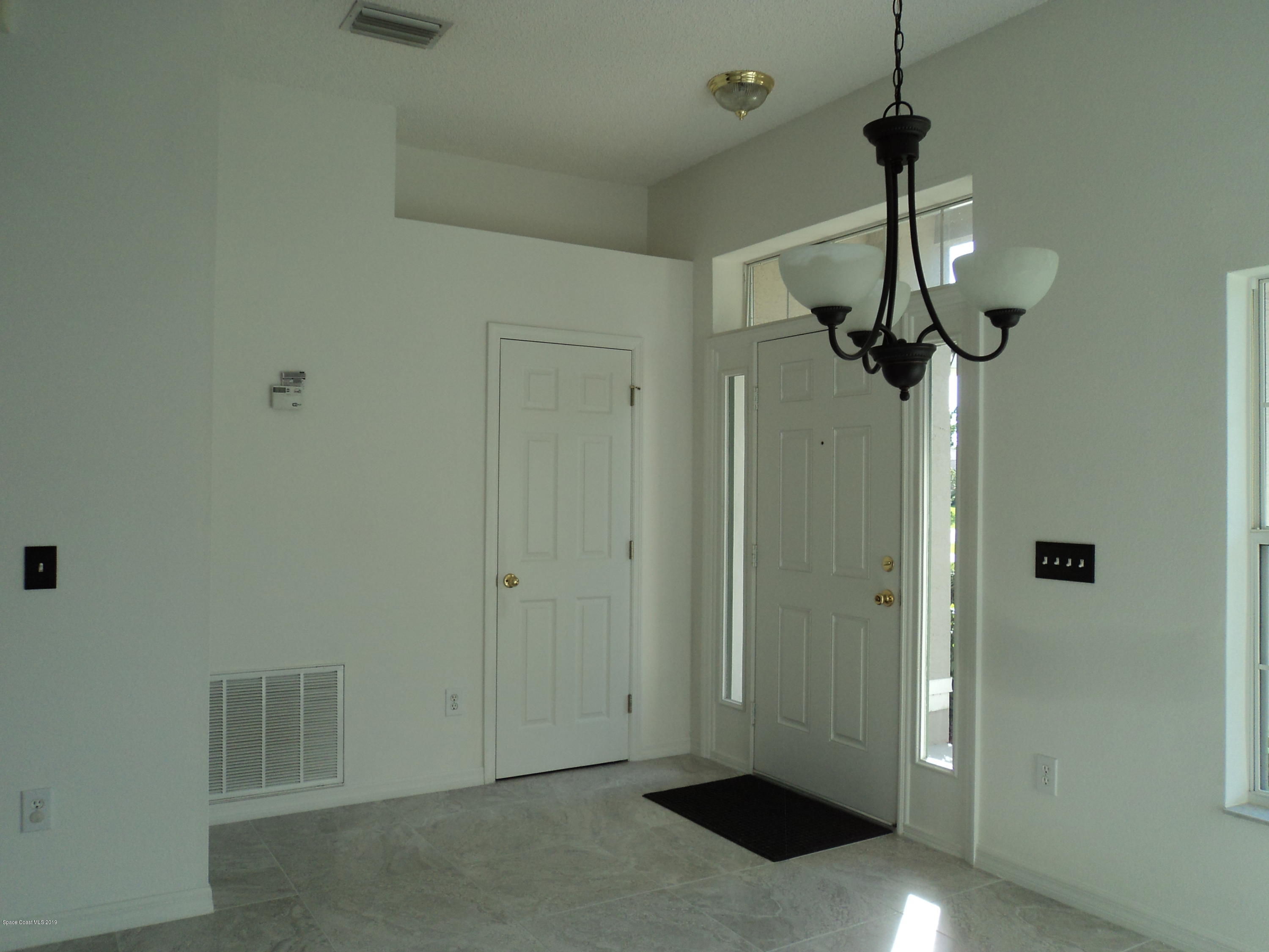 1685 Wacker Avenue Southeast Palm Bay, FL 32909 - Photo 9 of 30 a view of hallway with chandelier